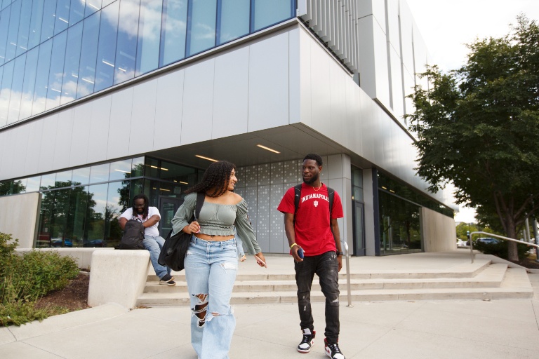 Two people walking out of Innovation Hall, talking.